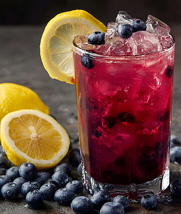 A Glass Of Blueberry Lemonade With A Lemon Slice