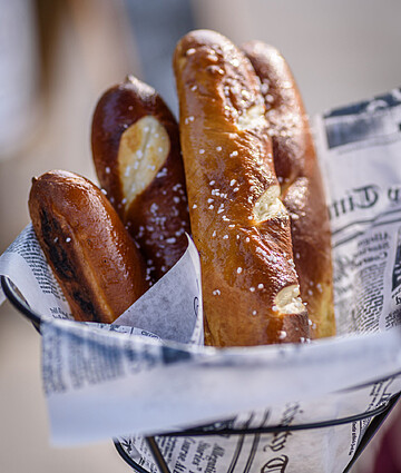 Fresh Bavarian pretzels in a rustic basket, perfect for outdoor dining and sharing.