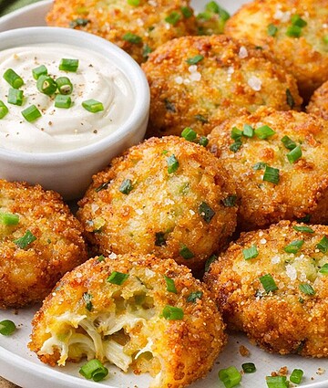 Golden-fried potato cakes garnished with green onions, served with creamy sour cream dip. Ideal for foodservice and wholesale distribution.
