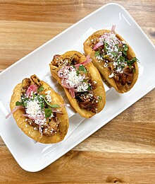 Crispy tacos filled with savory meat, cheese, cilantro, and vibrant pickled onions.