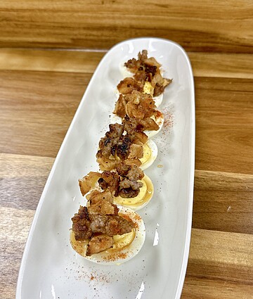 Delicious deviled eggs topped with crispy bacon for a modern twist on a classic appetizer.