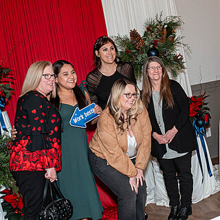 Five professional women at a festive food industry networking event, celebrating collaboration and leadership in foodservice and wholesale distribution.