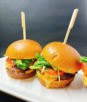 Delicious gourmet sliders featuring fresh ingredients and bold flavors on a sleek plate.