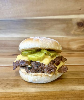 Juicy burger with melty cheese and fresh pickles on a golden bun.