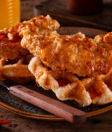 Savory chicken and waffles topped with spicy honey sauce, a delightful southern comfort meal.