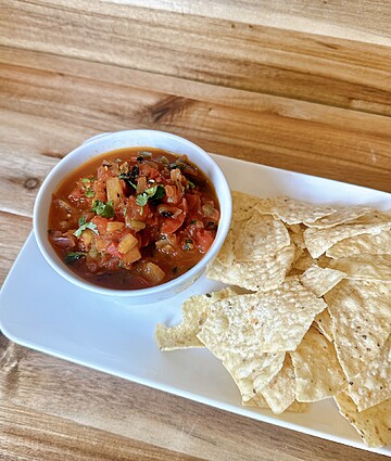 Delicious tortilla chips served with fresh, zesty salsa in a cozy setting.