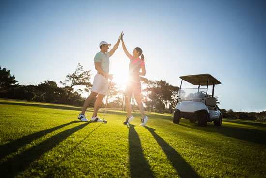 Happy Golf Player Couple Giving High Five