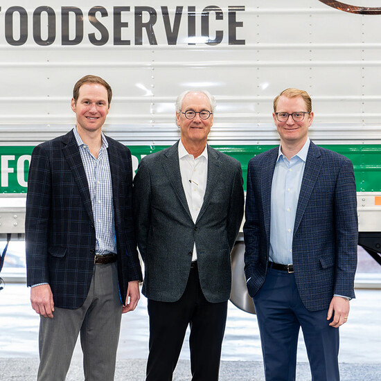 Professional team in food service industry standing in front of a delivery truck.