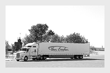 Monochromatic Van Eerden truck parked in a serene rest area, highlighting long-haul transport solitude.